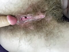Hairy girl screws her raw ginormous joy button pussy with faux-cock in close up